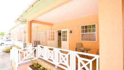 Charming terracotta patio with a small table and chairs behind a white wooden railing at Worthing Court Apartment