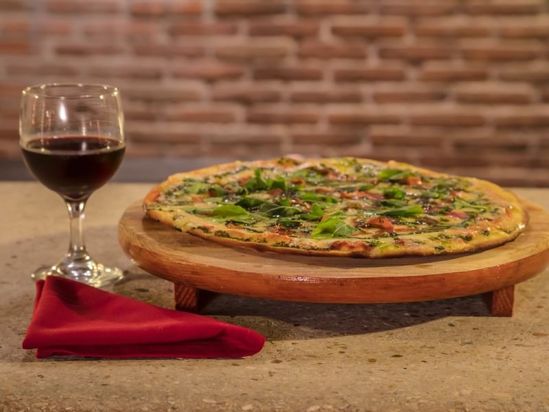 Pizza with wine served in Trattoria at FA Hotels & Resorts