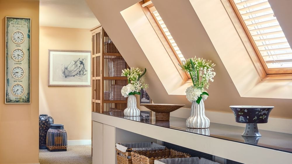 Hotel Westminster Paris spa hall featuring vases of flowers placed on a long counter, surrounded by baskets near windows