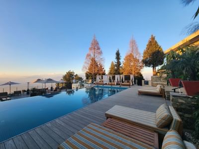 Infinity pool with lounge chairs overlooking a scenic horizon at The Terraces Resort & Spa