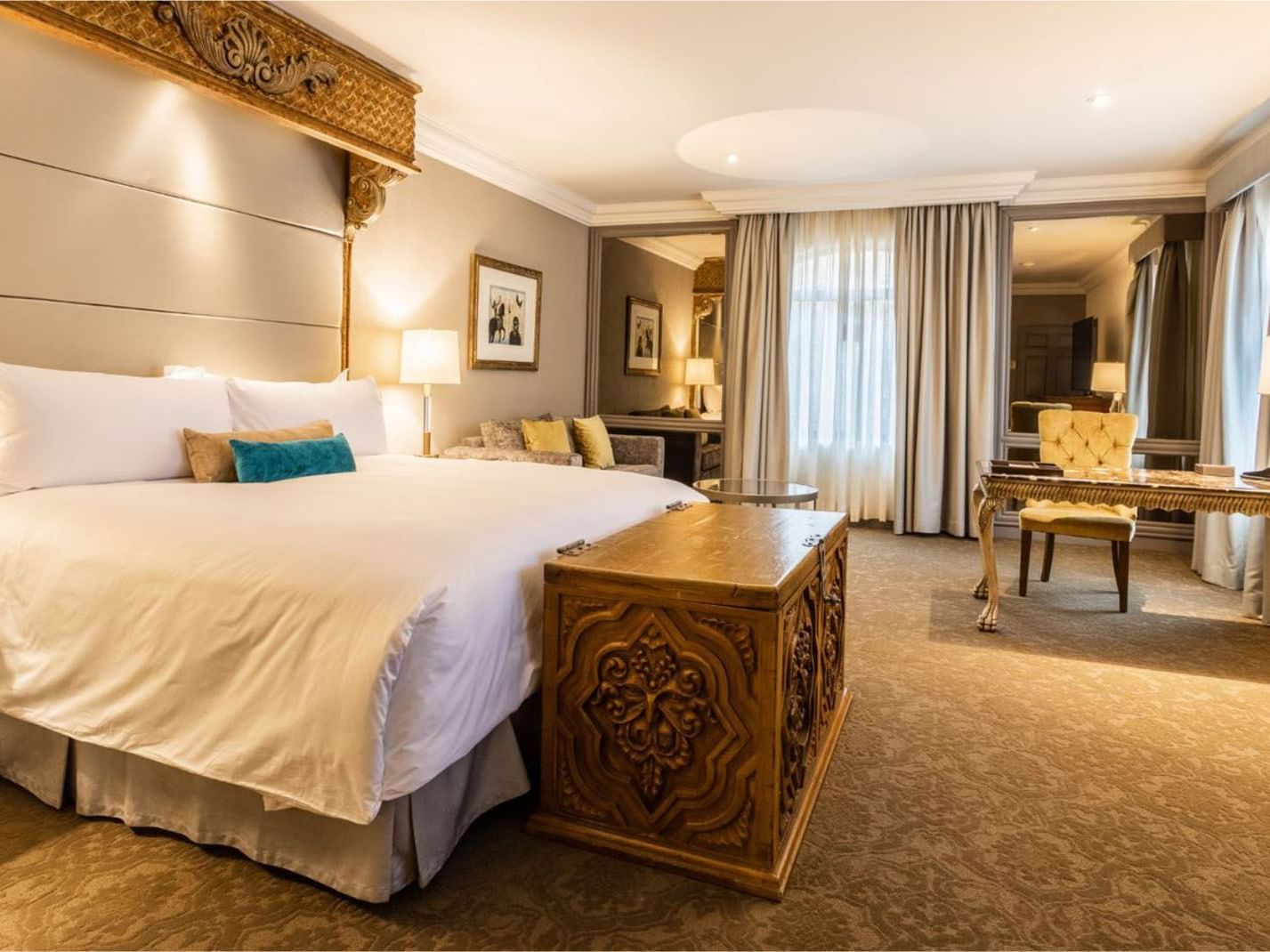 King Governor Suite with a large carved wooden chest at the foot of a king bed at Quinta Real Monterrey 