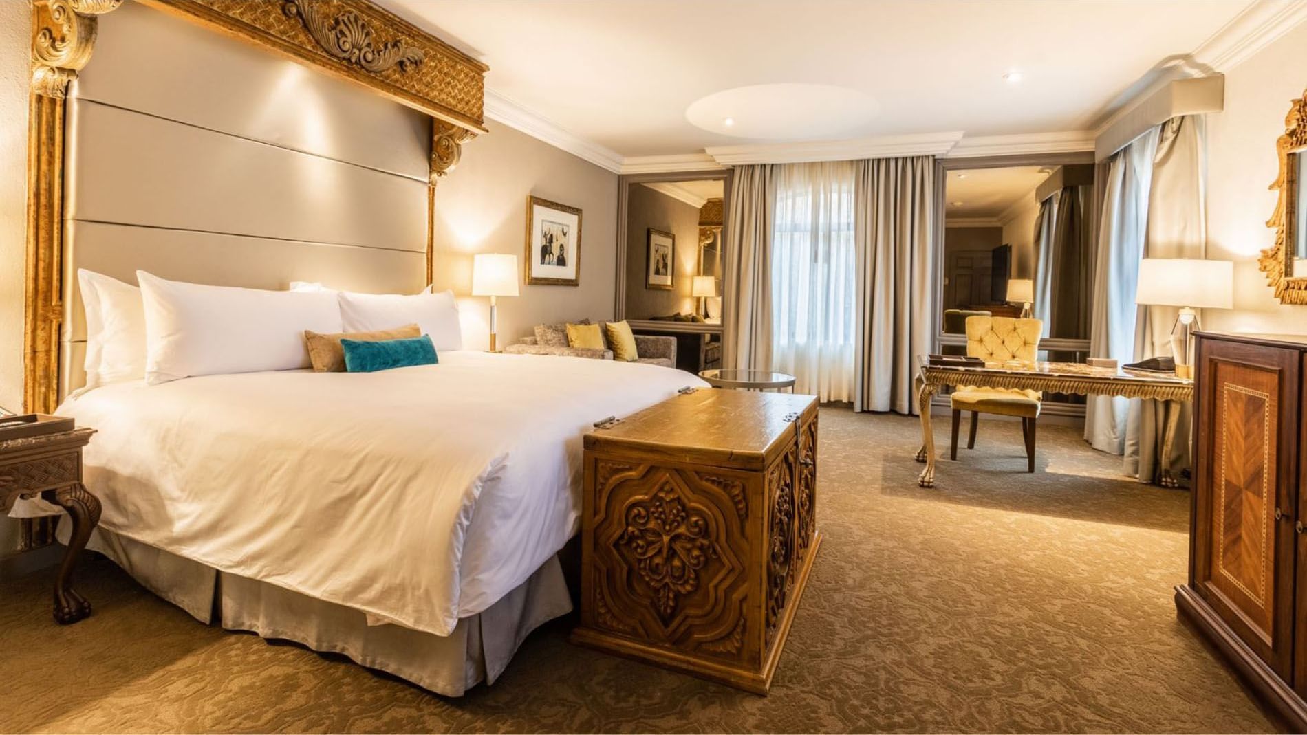 King Governor Suite with a large carved wooden chest at the foot of a king bed at Quinta Real Monterrey 