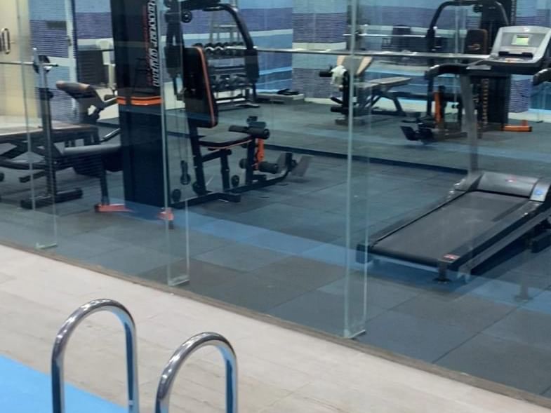 صالة رياضية مجهزة تجهيزًا جيدًا تطل على المسبح في فنادق ومنتجعات وارويك