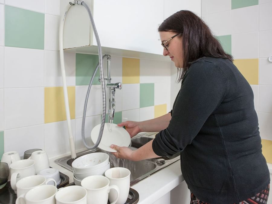 A lady washing glassware at Plume Hotel