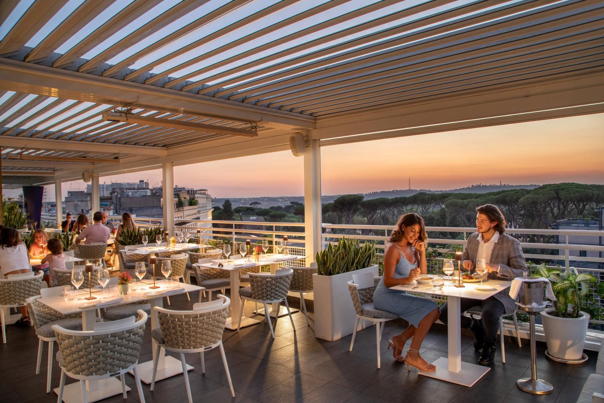 Terrazza Borghese with set tables and diners enjoying a picturesque view of the city skyline at The Tribune Hotel