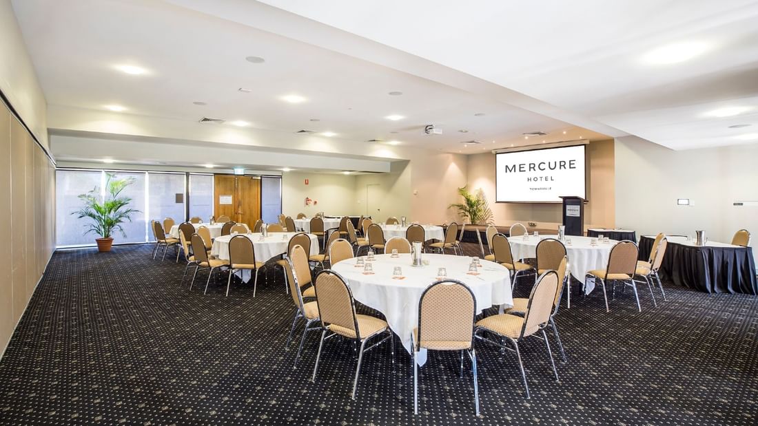 Crystal Room featuring round tables and a projector screen at Mercure Hotel Townsville