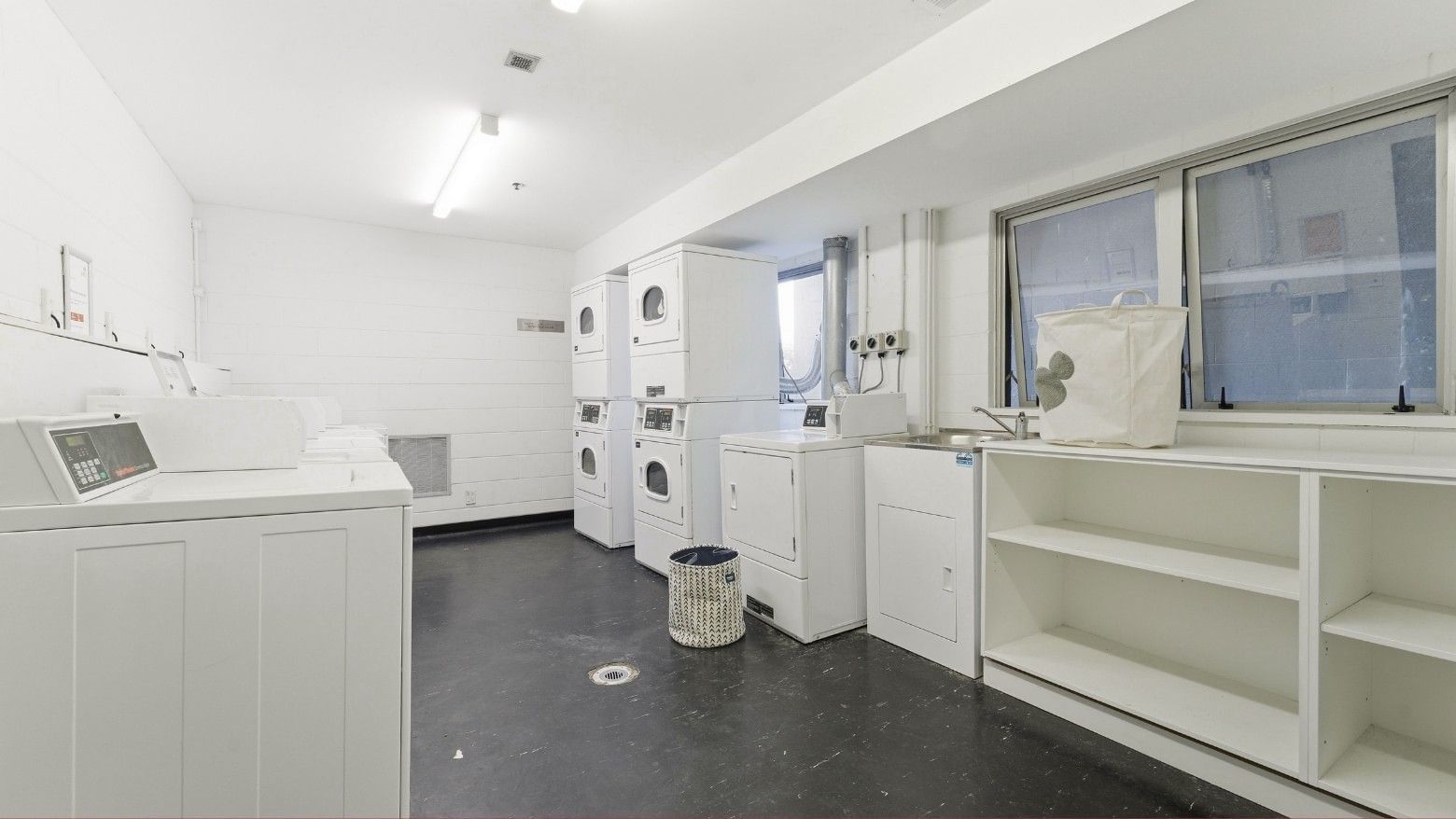 Clean laundry room with washing machines, dryers, and a sink at Student Living Auckland – Anzac.