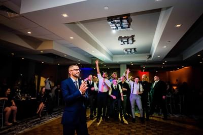 groom standing on dance floor affter throwing garter