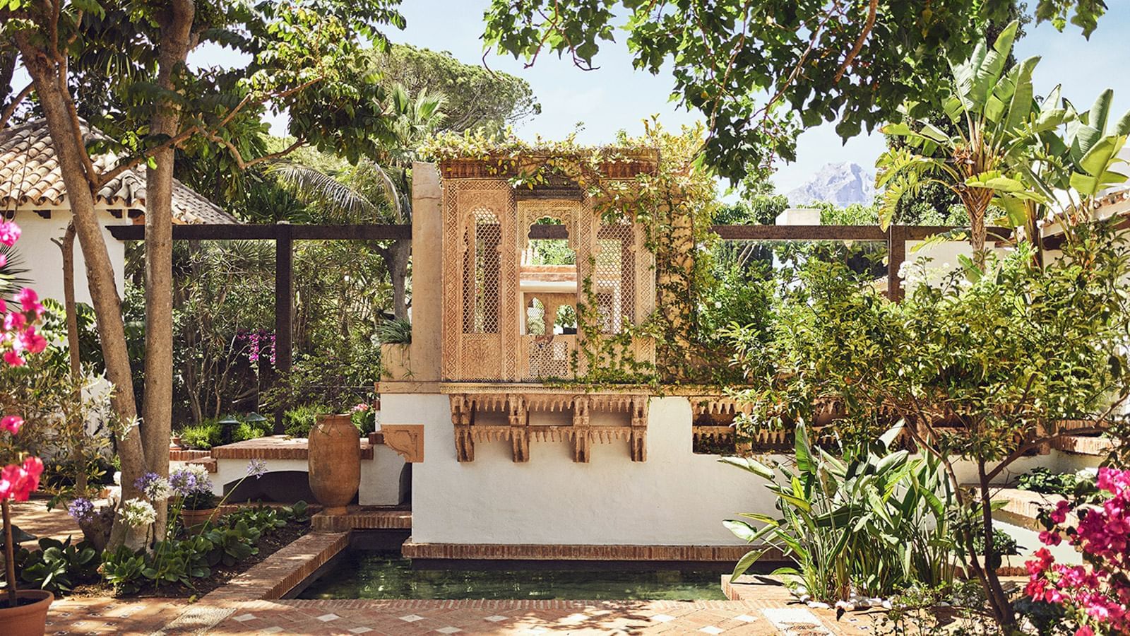 Outdoor garden with a Moorish-style stone fountain and small pool, surrounded by foliage at the Marbella Club