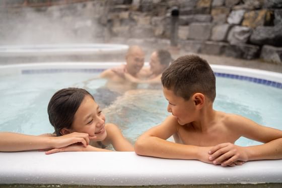 A family lounging in a Heated Pool at Blackstone Mountain Lodge