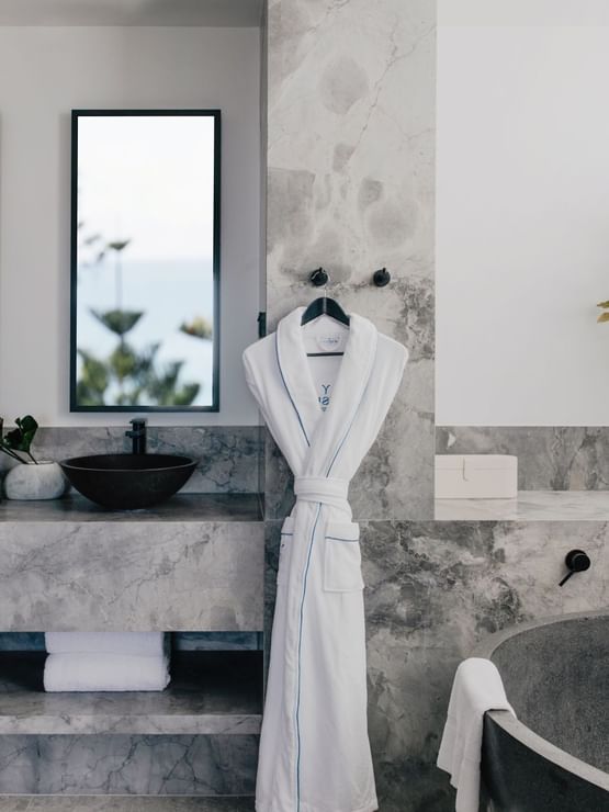 Elysium Suite at Elysium Manly with a black stone tub by twin vessel sinks under mirrors, offering cozy Manly accommodation