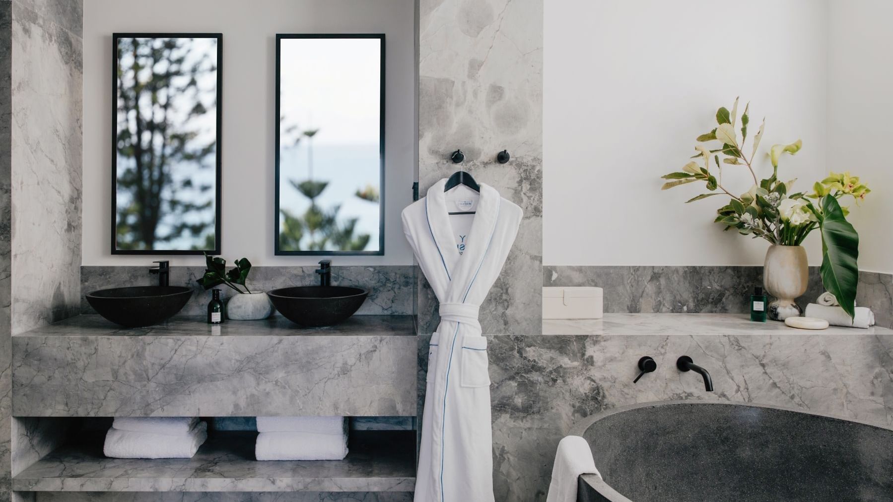 Elysium Suite at Elysium Manly with a black stone tub by twin vessel sinks under mirrors, offering cozy Manly accommodation