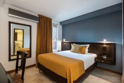 habitacion con cama king, ventana y espejo