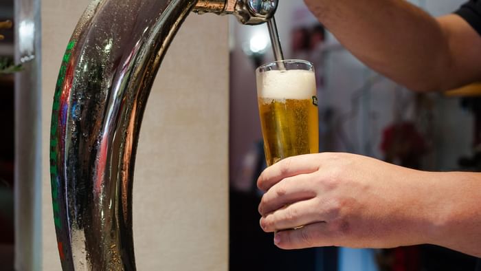 Barmen pours beer into a glass at Hotel eden