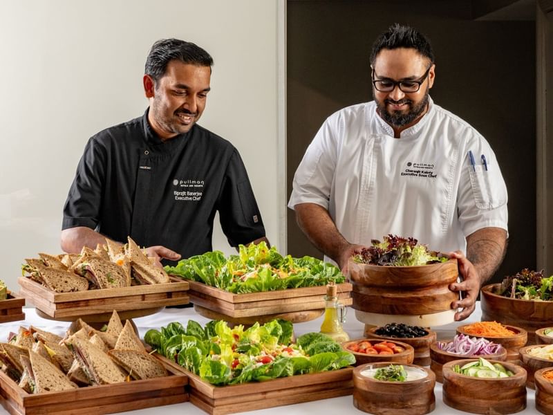 Chefs arranging salads and sandwiches area of the buffet in Windows on the Park Restaurant at Pullman Sydney Hyde Park