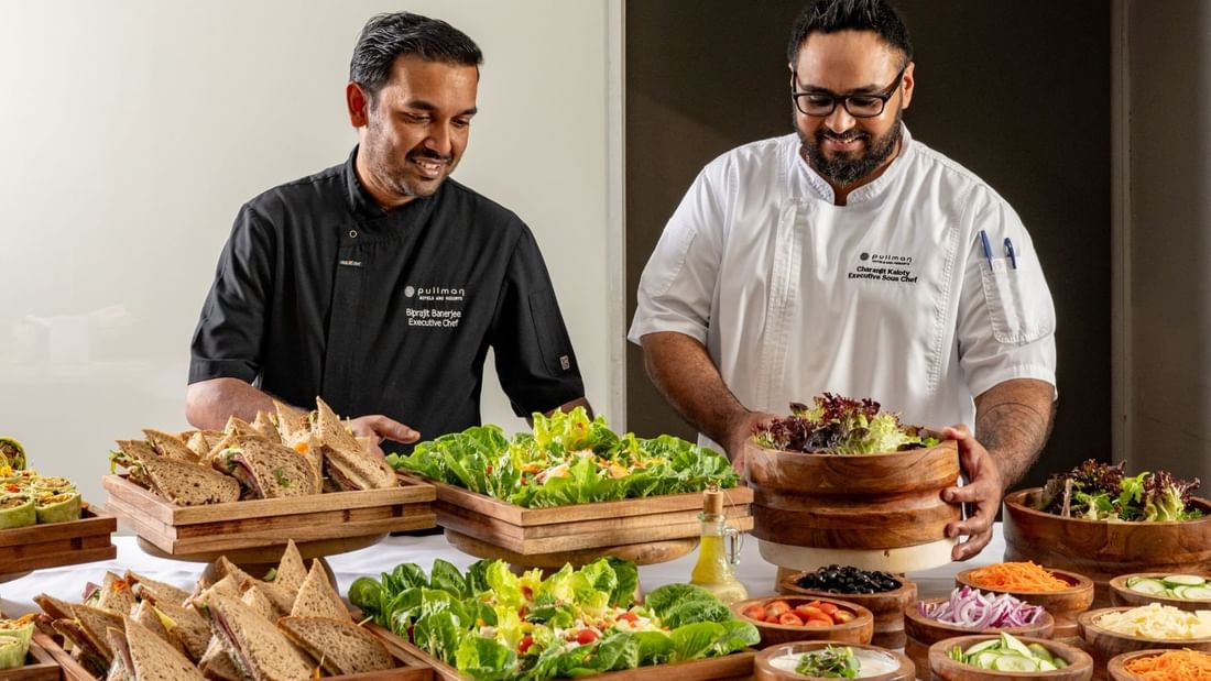 Chefs arranging salads and sandwiches area of the buffet in Windows on the Park Restaurant at Pullman Sydney Hyde Park