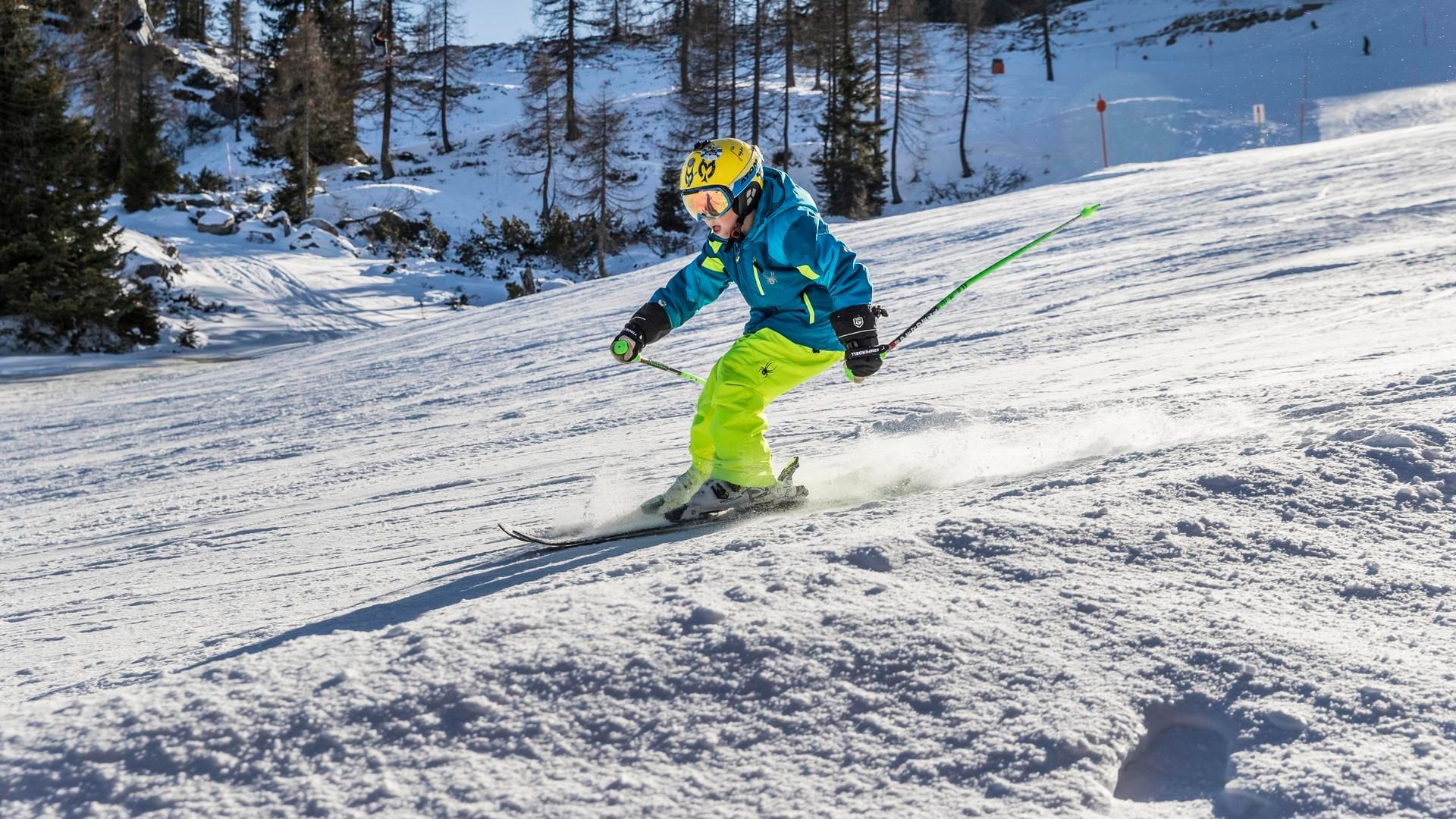 A kid skiing on snow near Falkensteiner Hotels