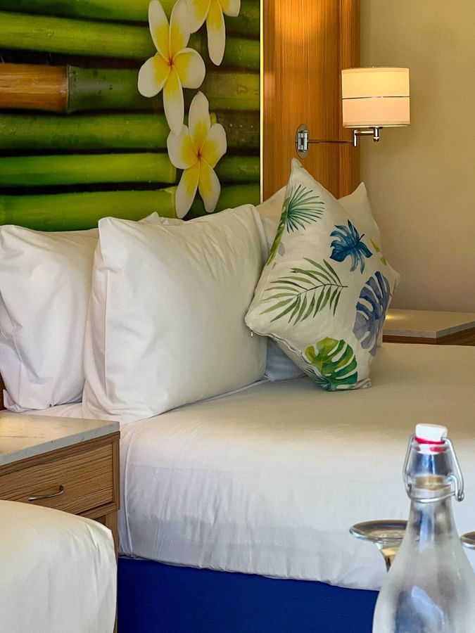 Comfortable beds with tropical decor and scenic garden view at The Naviti Resort in Korolevu.