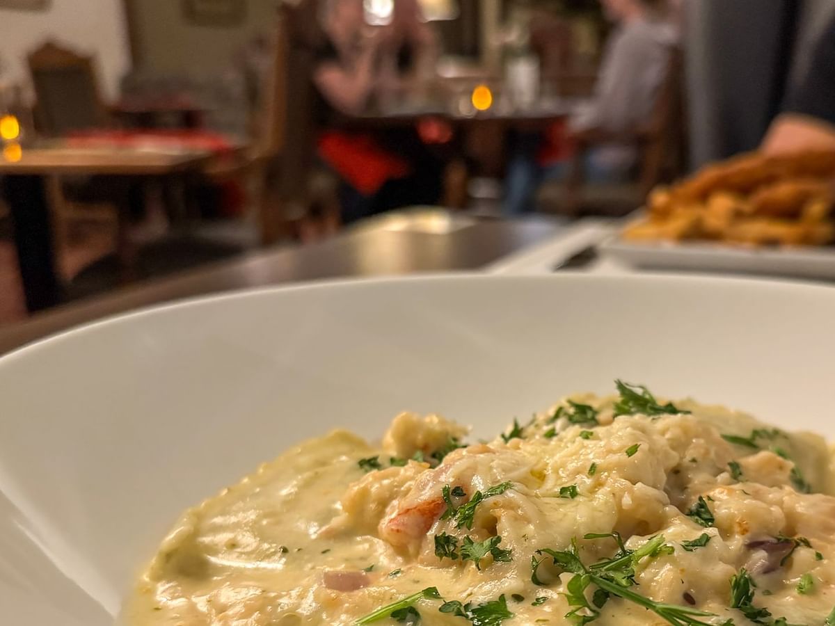 A close-up of a creamy seafood dish in a bowl.