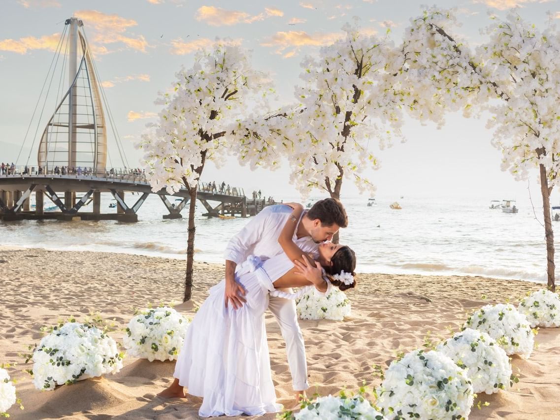 A wedding couple kissing in the beach at Playa Los Arcos