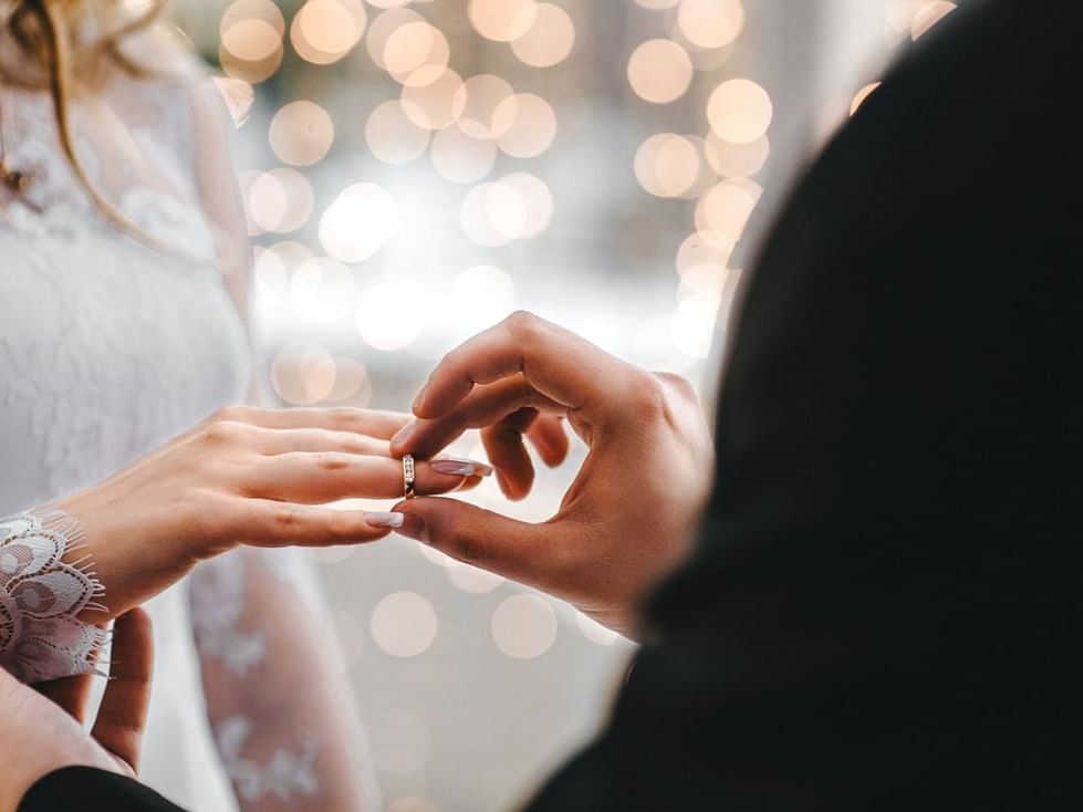 Close-up of the groom putting a ring on the bride's hand in a wedding at Alcyone Hotel Residences