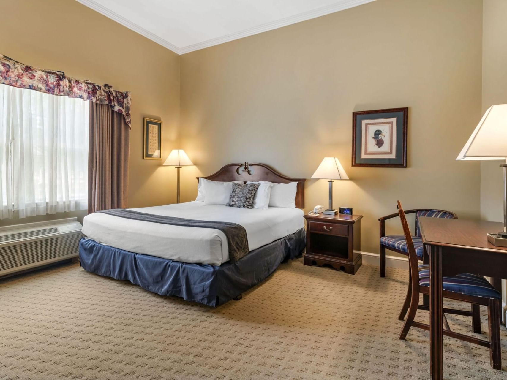 King bed, nightstand & workspace in Superior Rooms at The Bethel Inn Resort & Suites