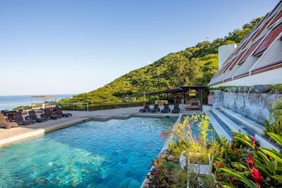 An outdoor pool with sun loungers arranged at Villas Sol Beach Resort