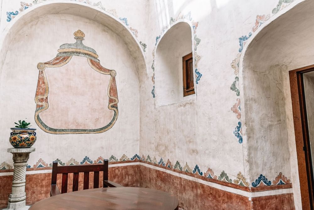 Intricate mural on a curved wall with archways in the King Governor Suite at Quinta Real Oaxaca