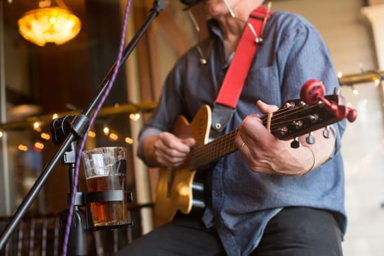 A man playing the guitar in a restaurant at The Inn Saratoga