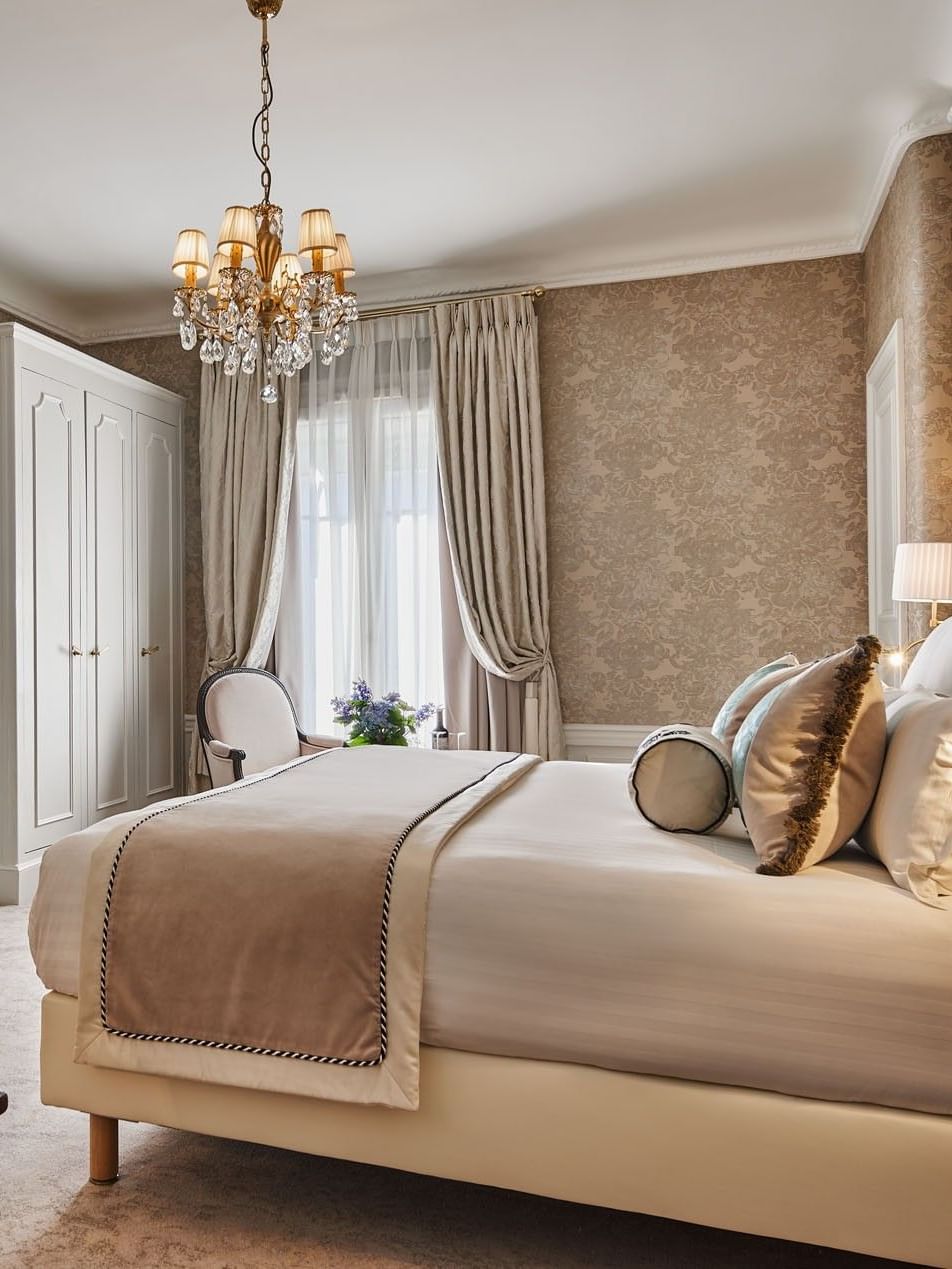 TV facing the bed with a couch & cupboard near the window in Executive Room at Hotel Westminster Paris