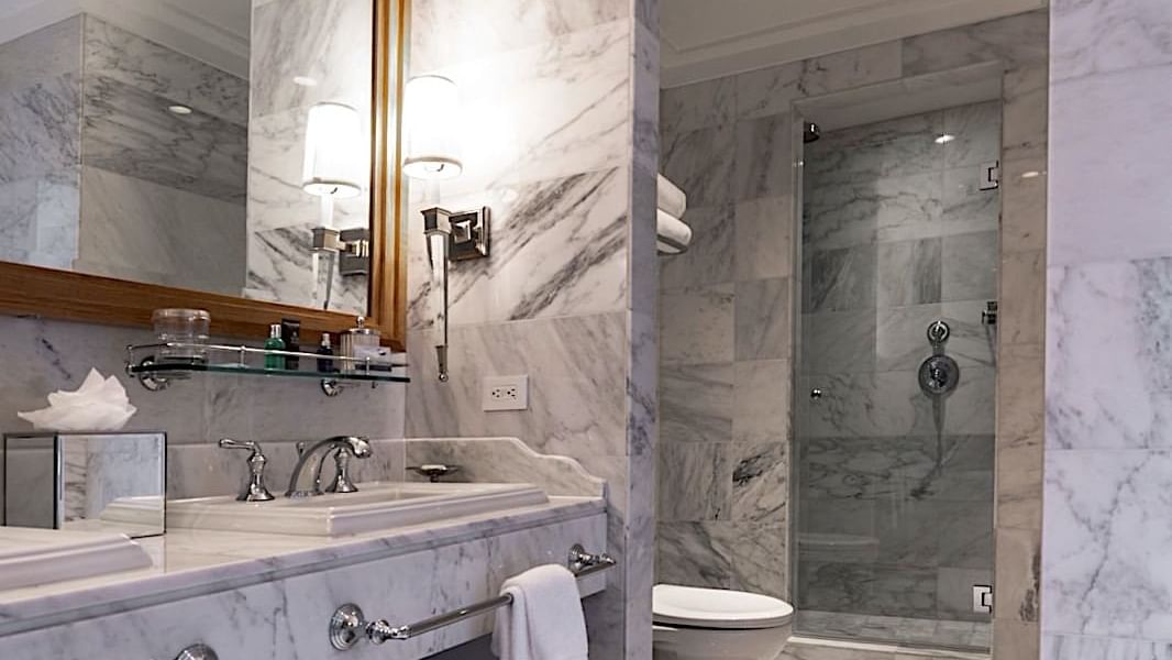 Bathroom with a mirror, vanity, and a modern glass-enclosed shower in Grand Deluxe Suite at El Prado Hotel