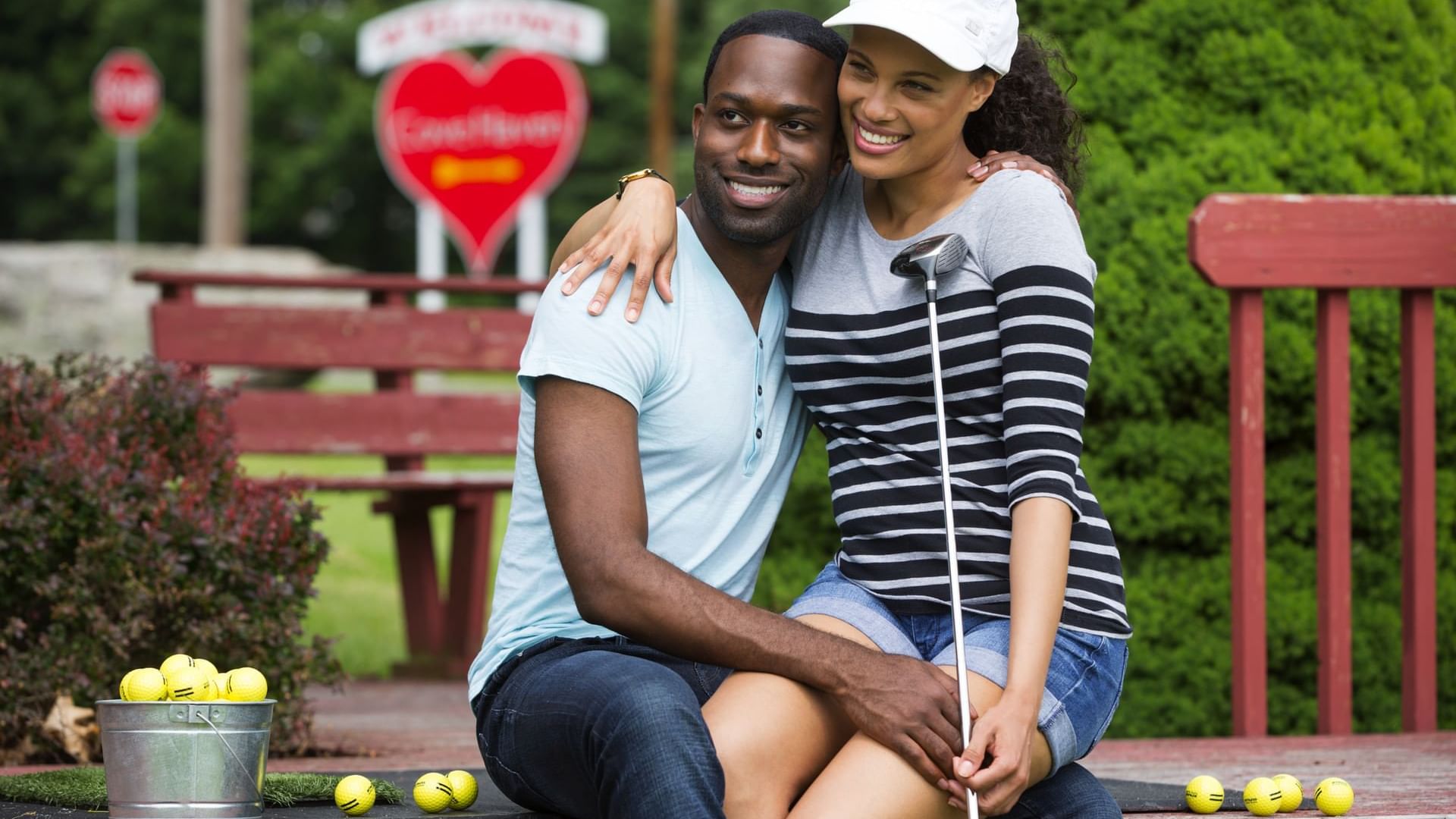 Lady sitting on her mans lap in the Golf Driving Range at Cove Pocono Resorts