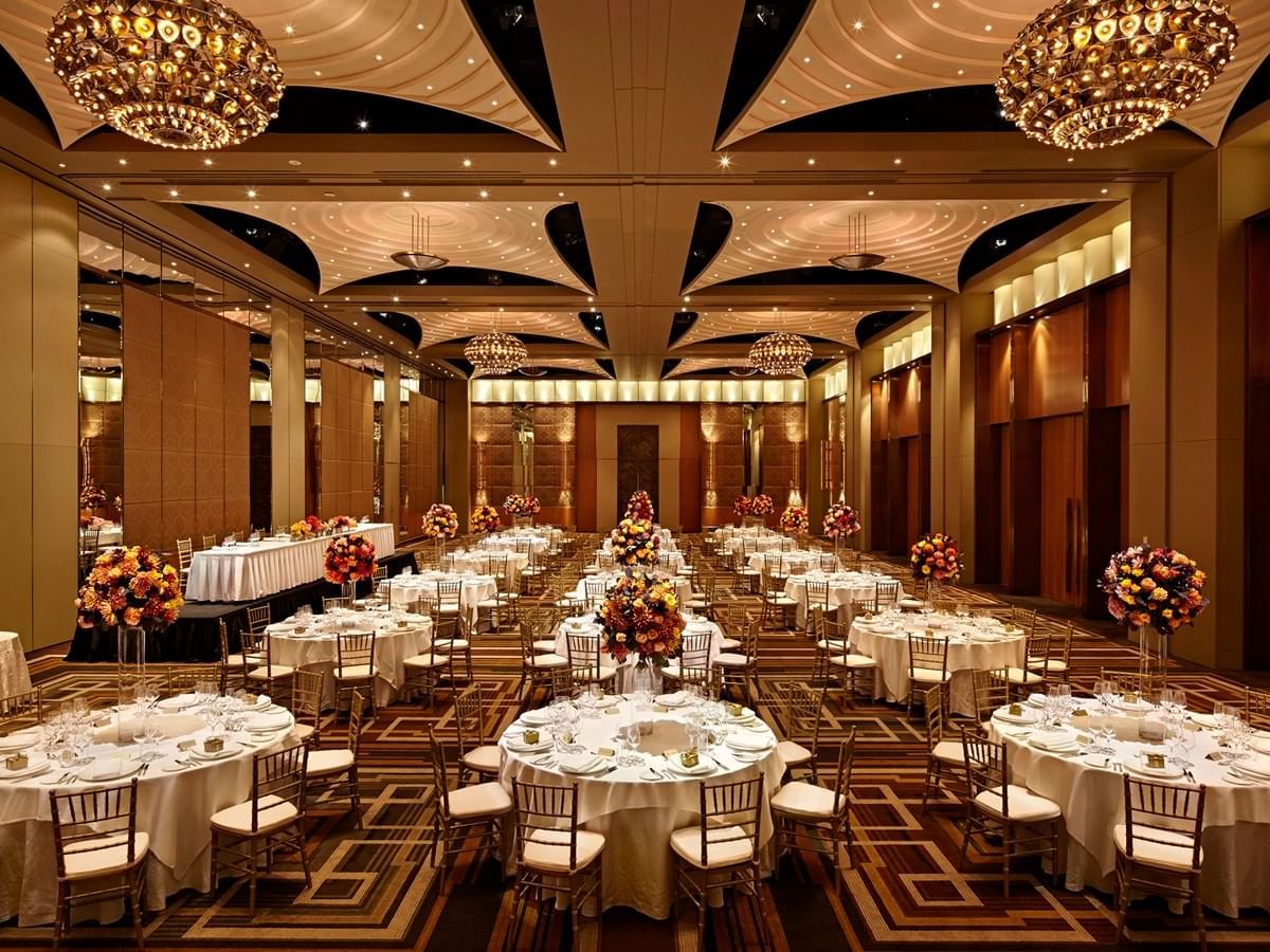 Banquet hall with round tables set for an event, ornate chandeliers at Crown Hotel Perth