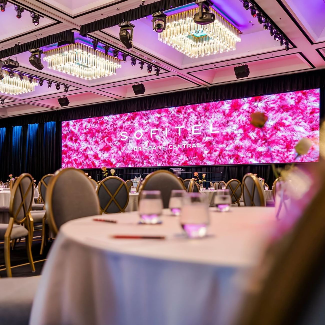 A spacious banquet room featuring elegantly arranged tables and chairs in Ballroom Le Grand at Sofitel Brisbane Central