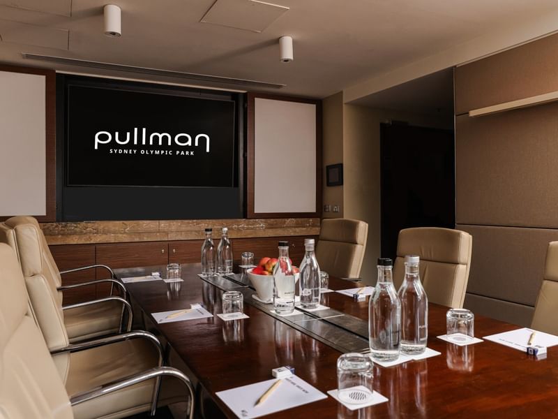 Meeting room setup with a large table and chairs at Pullman Sydney Olympic Park.