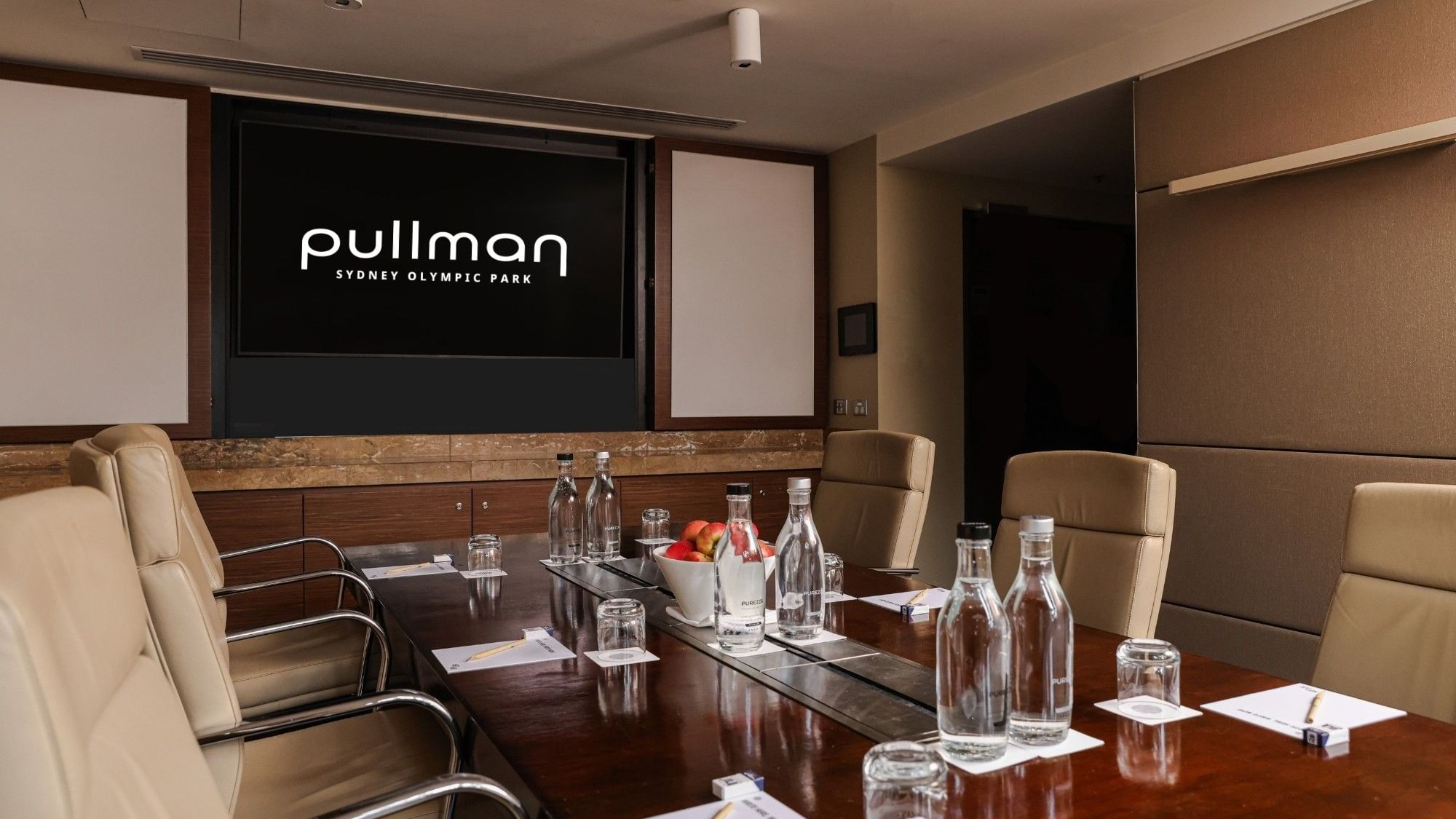 Meeting room setup with a large table and chairs at Pullman Sydney Olympic Park.