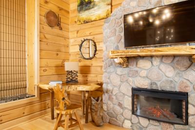 Fireplace, TV & live edge wooden desk with chair in King Executive Log Cabin at Retro Suites Hotel