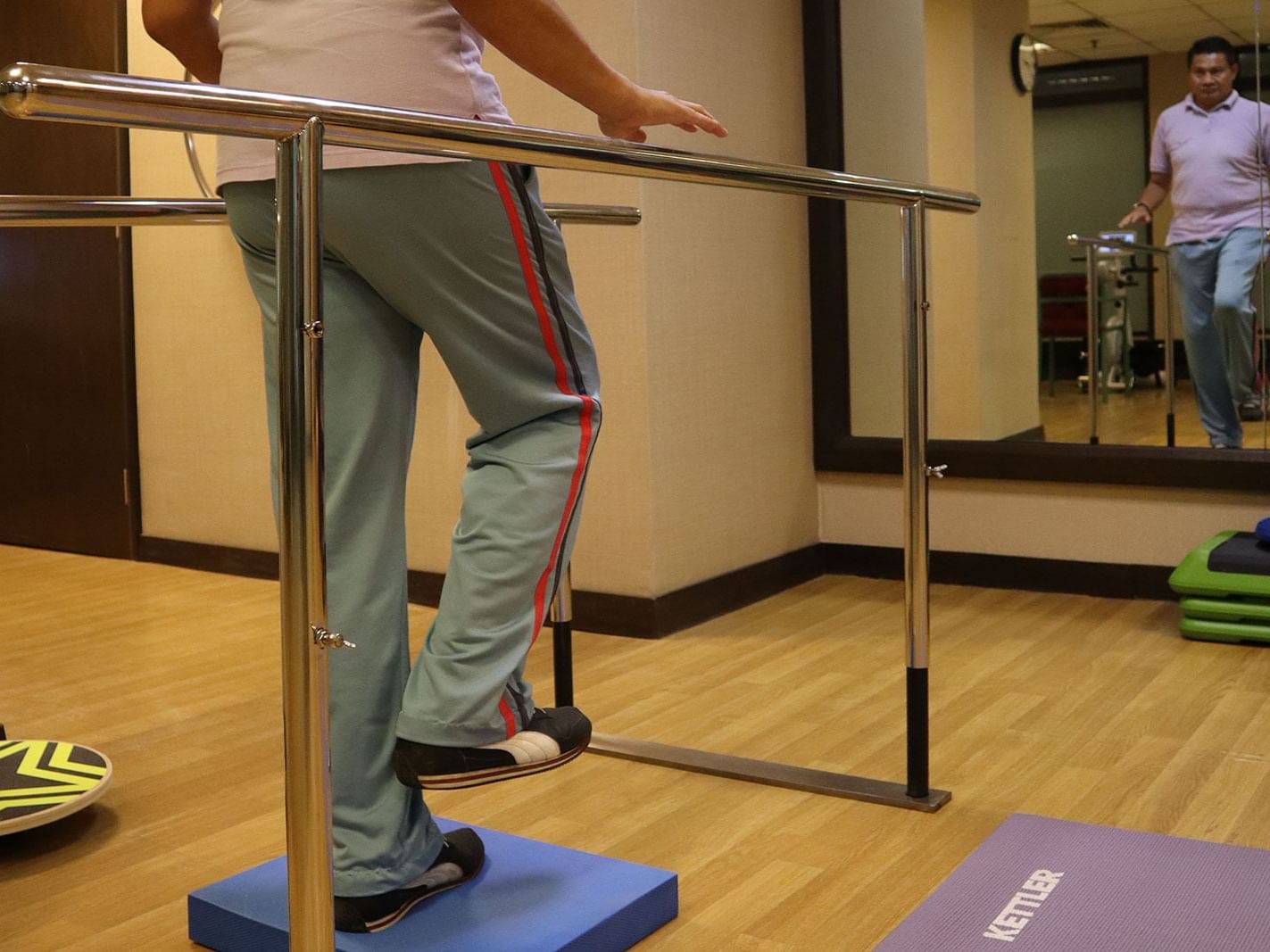 A person balancing on a bar in a Gym wellness center at MiCasa All Suite Hotel KL