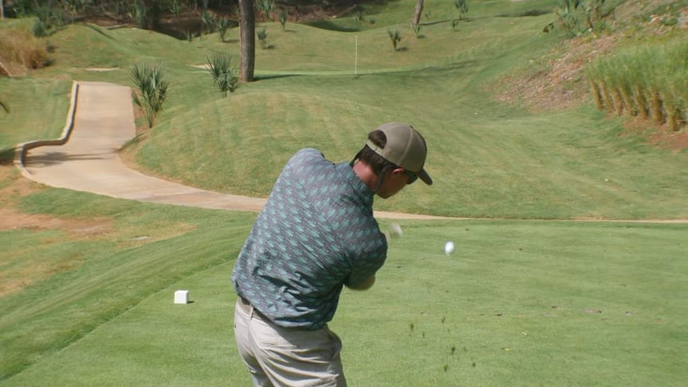 man hitting golf ball with club