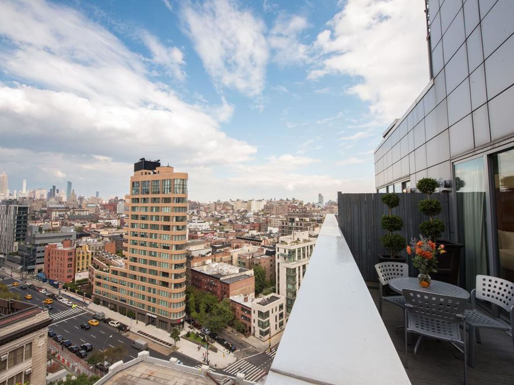 Stunning city view from a hotel balcony at Soho 54 in NYC, featuring outdoor seating featuring pre-pay and save offer