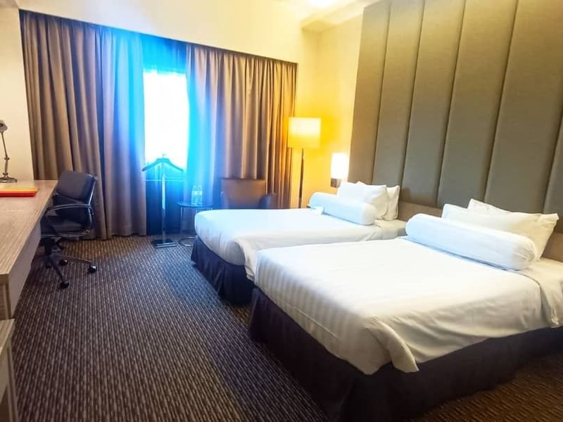 Premier Twin Room with two beds, a desk, and an armchair by the window at Sunway Hotel Seberang Jaya