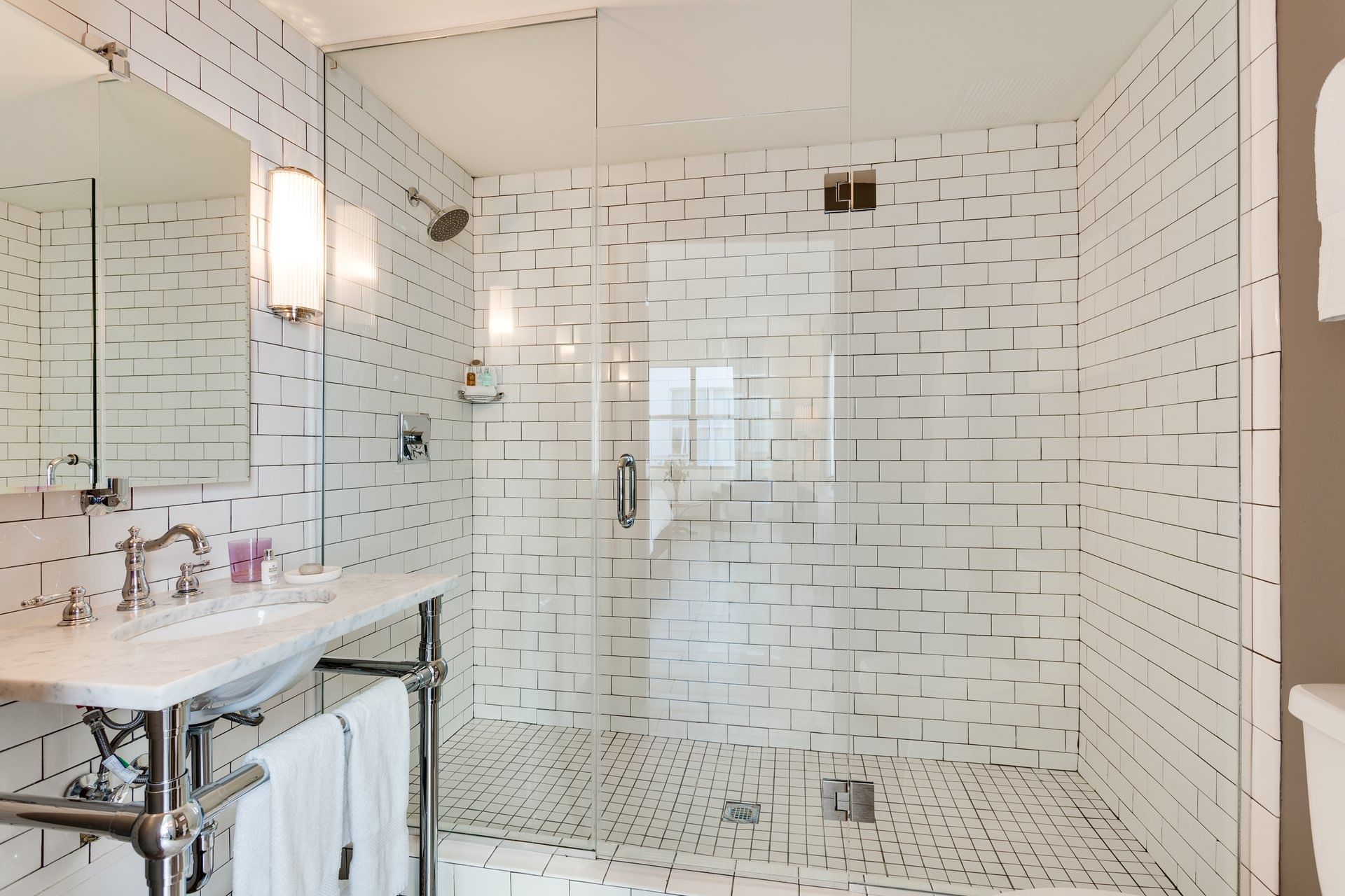 A bathroom with a shower, vanity, and mirror.