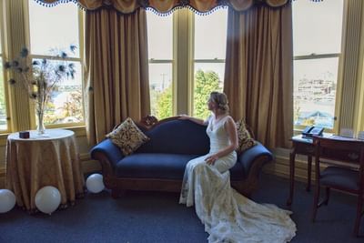 Lady sitting by the window lounge in a wedding dress at Pendray Inn & Tea House