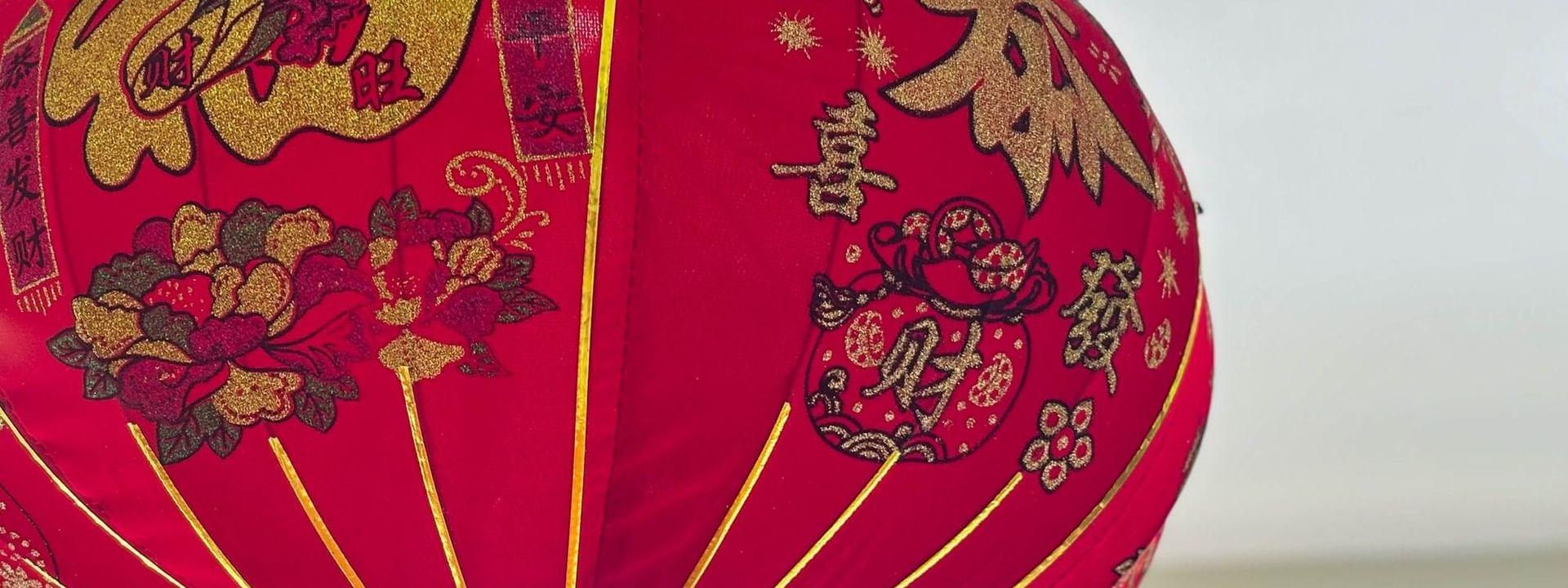 Red Chinese lantern with golden designs hanging from ceiling at Bamboo Terrace, The Naviti Resort in Korolevu