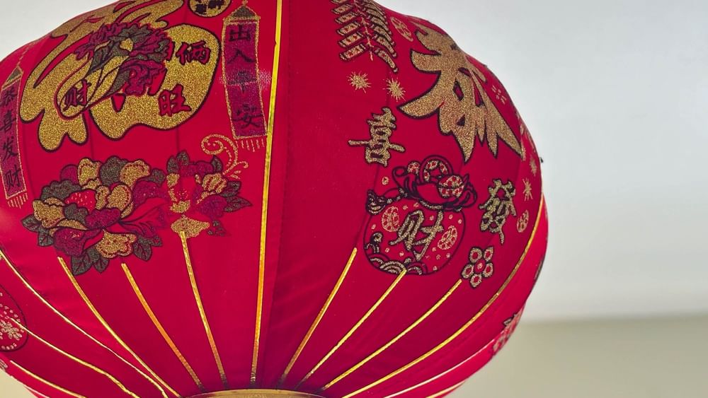 Red Chinese lantern with golden designs hanging from ceiling at Bamboo Terrace, The Naviti Resort in Korolevu.