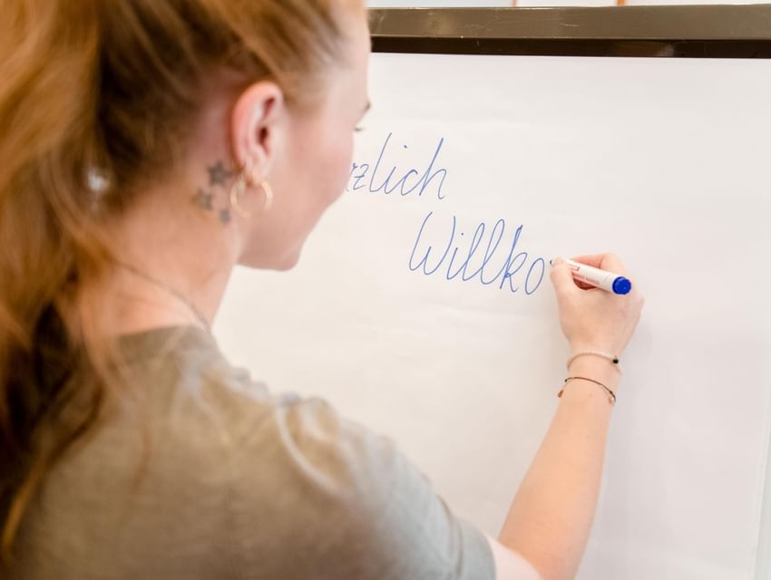 Frau schreibt auf Flipchart im Vitalhotel Gosau