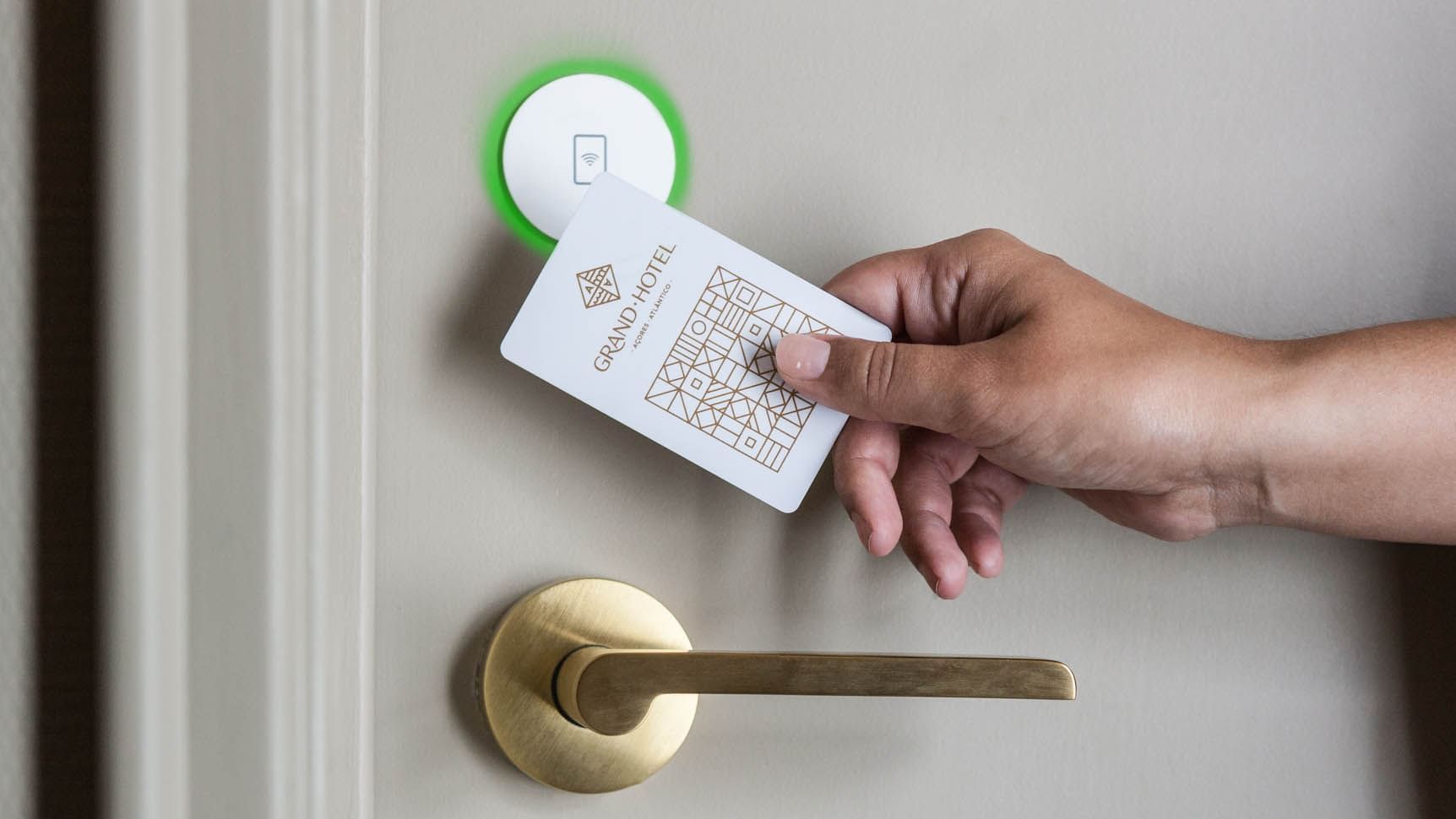 A person using an NFC keycard to unlock a door in Standard Plus City View Room at Bensaude Hotels