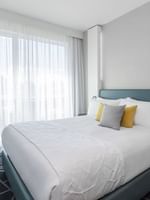 Bed with side tables near window in Penthouse René-Lévesque at Warwick Le Crystal Montreal