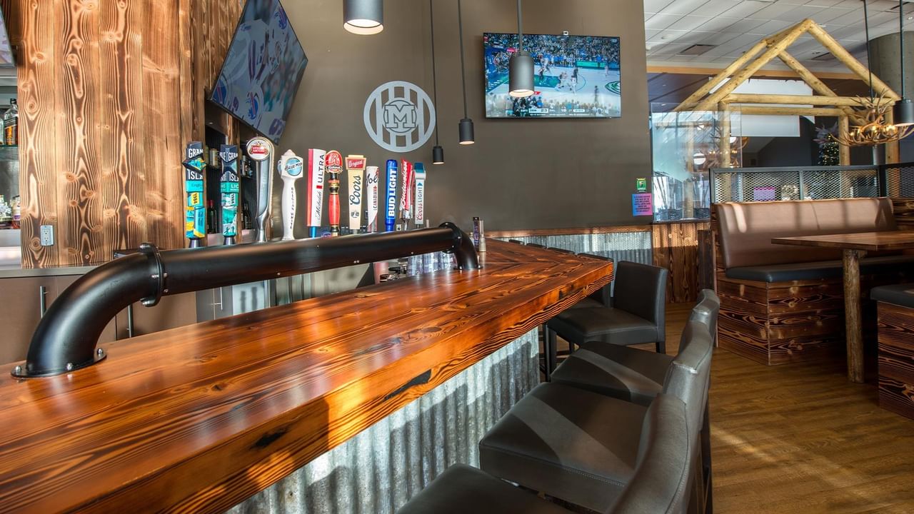 Wooden bar with metal accents and multiple beer taps.