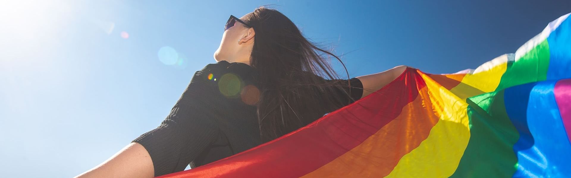 Girl looking at sky with pride flag at Mundo Imperial